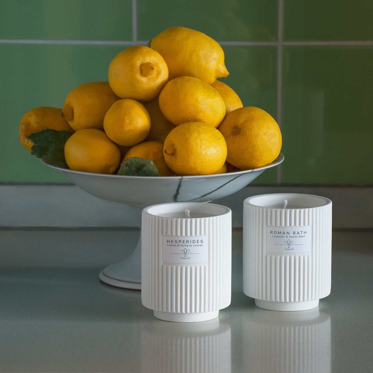Hesperides Classic candles in front of lemons.